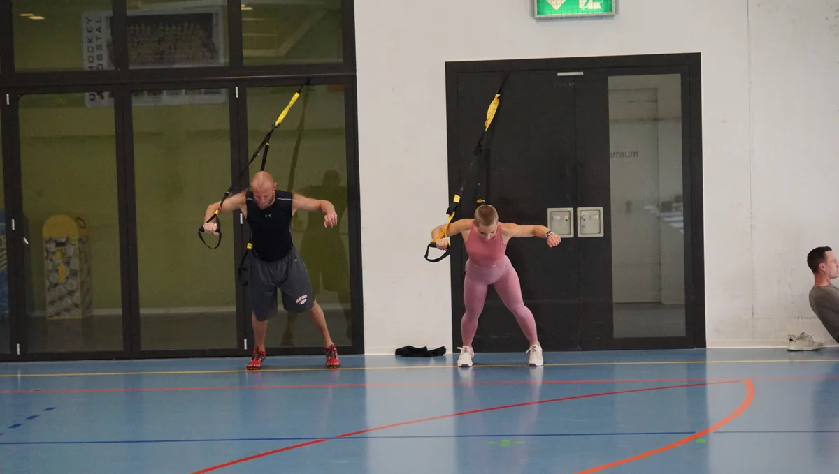 Man sieht Boller und eine Frau, die Luft-Liegestützen machen. 